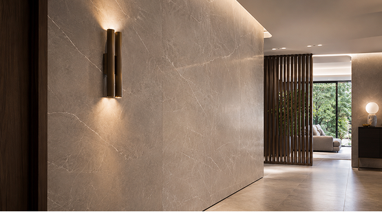 Modern hallway featuring illuminated large-format stone wall cladding panels with sleek wall sconce lighting